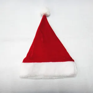 Gedetailleerde macro-opname van de rode kerstmanmuts van goudfluweel met witte pluche trim.