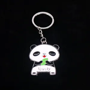 Close-up van een grote metalen panda-sleutelhanger met de tekst 'lovely' en een blad.