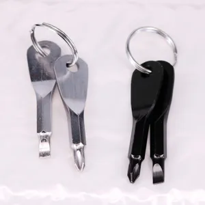 Detail shot of silver and black multi-tool screwdriver keychains on white surface.
