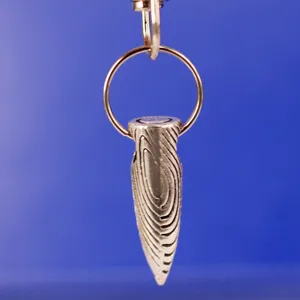 Dettaglio macro ravvicinato di un ciondolo a punta d'argento con venatura del legno unica
