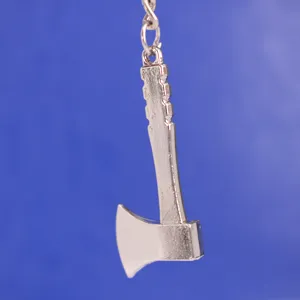 Detalle de un creativo llavero de hacha de metal plateado con diseño realista