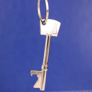 Detalle de un llavero abrebotellas de metal plateado con forma de llave antigua