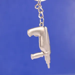 Detalle de primer plano de un llavero creativo de metal plateado con forma de taladro