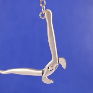 Primer plano detallado de un llavero creativo con forma de alicates de metal mate.
