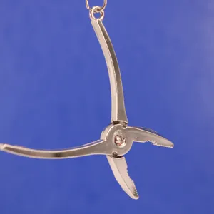 Primer plano de un llavero creativo con forma de alicate para herramientas en metal plateado
