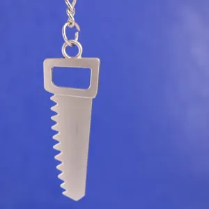 Detalle de primer plano de un llavero de metal plateado con forma de sierra sobre azul