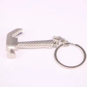 Primer plano de un llavero creativo de metal con forma de martillo plateado para hombres