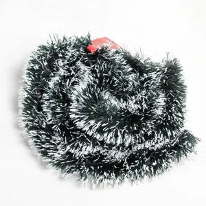 Macro view of 2m dark green Christmas tinsel garland with snowy white tips decoration