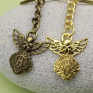 Detailweergave van vintage bronzen en gouden engelenvleugel sleutelhangers met verfijnde details