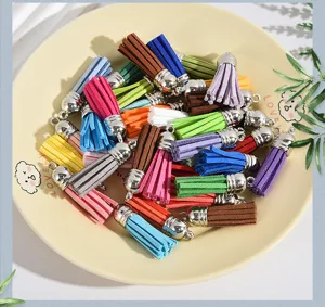 Macro view of multi-colored faux suede tassels with silver caps in a decorative dish