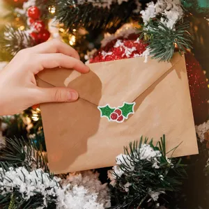 Glinsterende hulststicker die een kraft envelop verzegelt bij een versierde kerstboom.