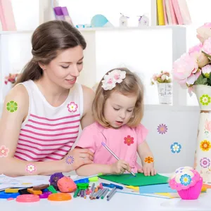 Une jeune fille et sa mère utilisent des autocollants de fleurs colorés pour l'artisanat
