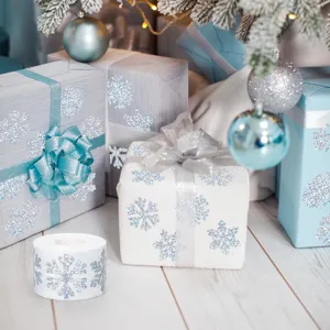Detalle de pegatinas de copos de nieve láser holográficos en cajas de regalo de Navidad plateadas