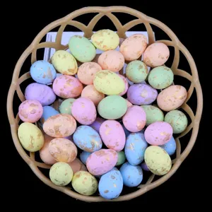 Close-up of colorful foam Easter eggs with gold speckles inside a small round basket