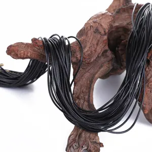 Close-up of black Korean wax cords for DIY necklace making on driftwood display