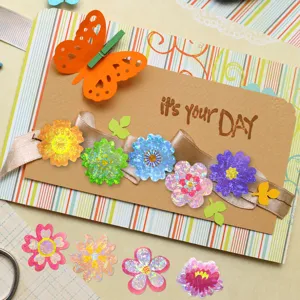 Macro detail of vibrant holographic flower stickers used for DIY greeting card decoration