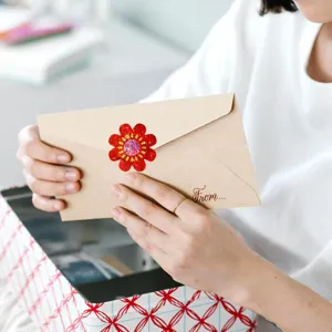 Detailed macro view of a red holographic flower sticker used as an envelope seal