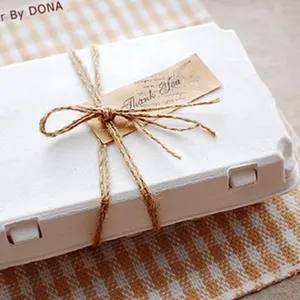 Dettaglio di spago di iuta naturale legato a fiocco su una confezione regalo.
