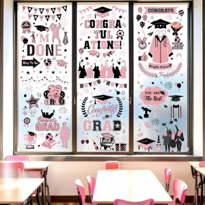 Roze afstudeer raamstickers set met toga's en felicitatieborden in een klaslokaal setting