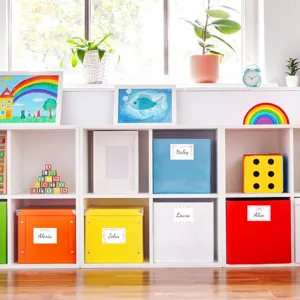 Pink bow design self-adhesive name labels applied to colorful storage bins in a nursery.