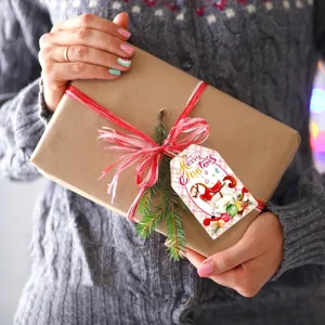 Pink Christmas gift tag with carousel horse design on a kraft paper wrapped present