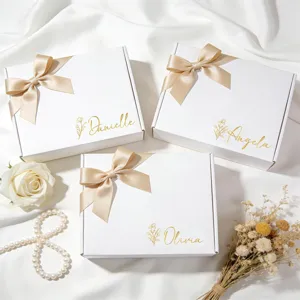 Nahaufnahme von goldenen personalisierten Namensaufklebern auf weißen Hochzeitsboxen.