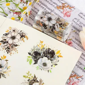 Detailansicht von floralen PET-Aufklebern auf einem Notizbuch und einer Stickerrolle.