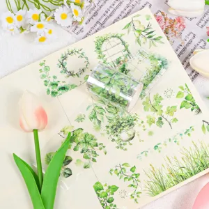 Nahaufnahme von botanischen PET-Aufklebern und Klebebandrolle auf einer Scrapbook-Seite