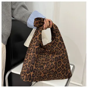 Gros plan détaillé d'un sac cabas léopard rétro tenu à la main dans un décor lifestyle