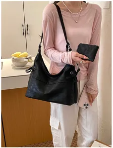 Bolso hobo informal de cuero suave negro con bolsa a juego en un entorno real