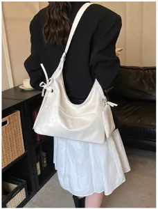 Vista detallada de un bolso hobo de cuero blanco con lazo y estuche pequeño