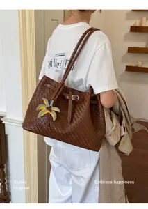 Detailaufnahme einer braunen Leder-Tragetasche mit Webmuster für den täglichen Gebrauch.