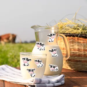 Detailed view of cute cartoon cow stickers applied on a glass milk pitcher in farm setting