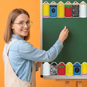 Teacher decorating classroom chalkboard with colorful pencil bulletin board borders