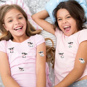 Detail view showing adorable cartoon cow stickers on kids arms and pink clothing during playtime
