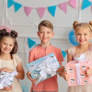 Children at a birthday party holding gift boxes decorated with cute cartoon cow stickers