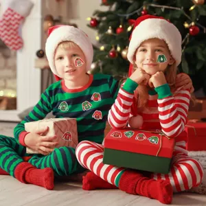Happy children using Christmas sweater stickers for holiday gift box decoration and joy