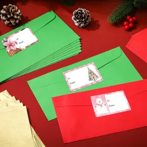 Detail van roze kerststickers met sneeuwpop en boomontwerpen op enveloppen.
