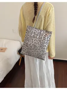 Stylish leopard print sequin tote bag for women shown on model in a cozy room setting