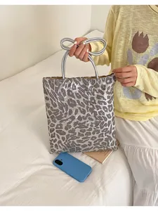 Detailed view of sparkly leopard print handbag with silver bow handle and tote design