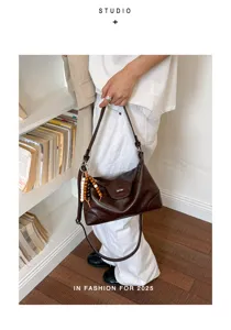 Dunkelbraune Leder-Tragetasche mit modischem Perlen-Accessoire in Lifestyle-Szene