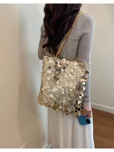Close-up of gold sequin tote bag showing shimmering scale-like details on model.