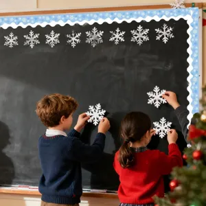 Close-up of children decorating a school blackboard with blue winter snowflake border stickers