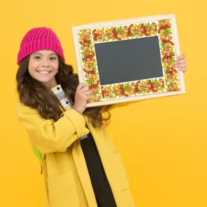 Close-up detail showing autumn leaf bulletin board border trim applied to a chalkboard