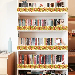 Decorative autumn leaf and berry bulletin board border stickers applied to bookshelf