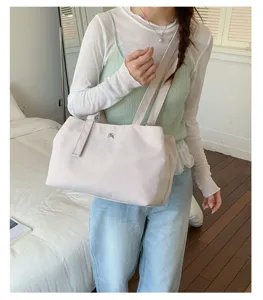 Elegant beige nylon commuter tote bag styled by a model in a cozy casual home setting