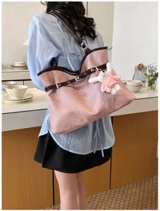 Vue détaillée du grand sac cabas rose avec lanières marron et breloque lapin mignonne.