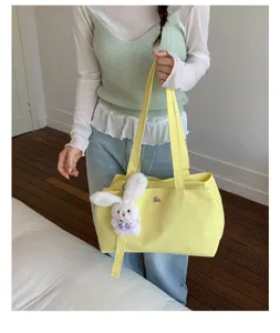 Vibrant yellow nylon tote bag with cute white rabbit charm accessory for daily use