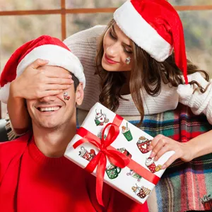 Christmas stickers on gift box and face in warm holiday gifting scene with couple.