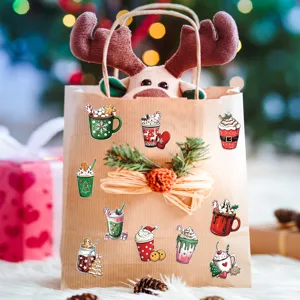 Assorted Christmas watercolor stickers applied to a kraft gift bag in holiday scene